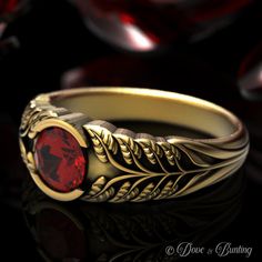 a gold ring with a red stone in the center and leaves on it's sides