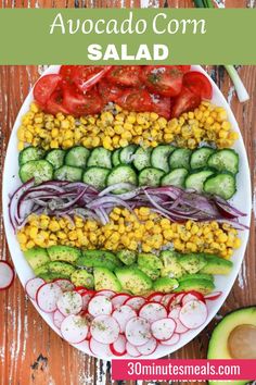 a plate filled with cucumber, corn and red onion salad on top of a wooden table