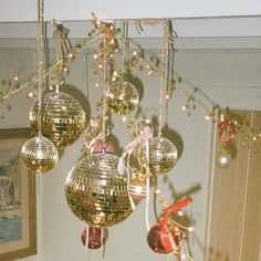 several disco balls hanging from the ceiling in a room with gold and red decorations on it