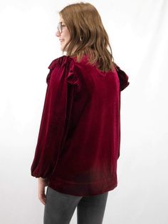 Dress in opulent elegance with this luxurious velvet top in a rich burgundy hue. The frilled neck and ruffled shoulders add a touch of romance, while the long peasant sleeves exude a bohemian charm. The back keyhole detail adds a subtle allure to this enchanting piece, making it a perfect choice for adding a touch of sophistication to your evening or special occasions. SIZE & FIT Fit is true to size Model is 5'6" wearing size small﻿ FABRIC 100% Polyester Peasant Sleeve, Rich Burgundy, Velvet Top, Velvet Tops, Red Top, Special Occasion, Romance, Velvet, Fabric