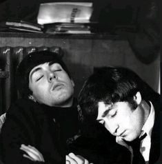 two men sitting next to each other with their eyes closed