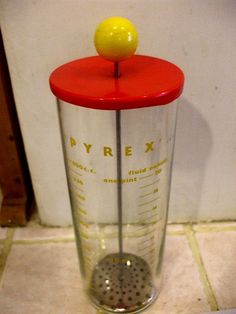 a red and white blender with a yellow ball on top