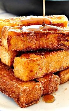 french toast with syrup being drizzled onto it and stacked on top of each other