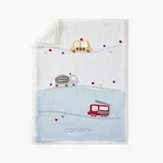 a white blanket with a train and cars on it