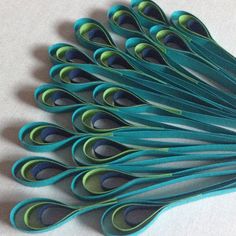 a bunch of blue and green paper peacocks