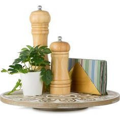 a wooden pepper mill sitting on top of a table next to a potted plant