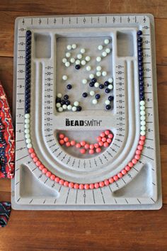 a plastic tray with beads on it and a measuring tape in front of it that says bead smith