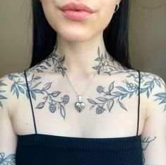 a woman with tattoos on her chest is looking at the camera