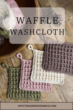 three crocheted washcloths sitting on top of a wooden table next to yarn