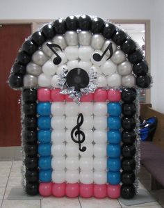 an inflatable house with music notes on it and balloons attached to the front