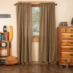 a living room with wooden floors and curtains on the windowsills, bookshelves, and an old fashioned clock