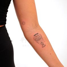 a woman's arm with a tattoo on it that has a cup and saucer