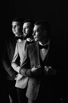 three men in tuxedos are posing for a black and white photo with their hands on their hips