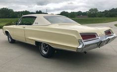 an old car is parked in a driveway