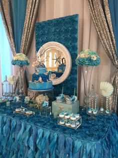 a table topped with blue and white desserts next to a mirror on top of a wall