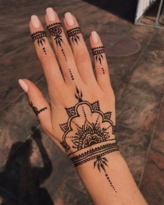 a woman's hand with hennap tattoos on her left wrist and fingers