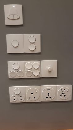 four switches and two outlets are on the wall next to each other in this room