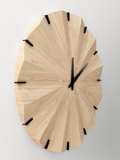 a wooden clock with black hands on a white wall