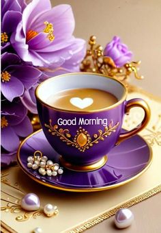 a cup of coffee sitting on top of a saucer next to purple flowers and pearls