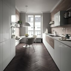 a modern kitchen with white cabinets and wood flooring, along with a dining table