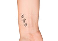 a woman's arm with a small turtle tattoo on it