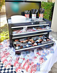 a table topped with lots of cupcakes and cake next to a flat screen tv