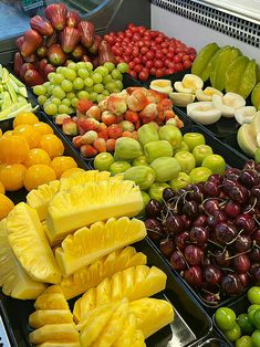 an assortment of fruits are displayed in trays