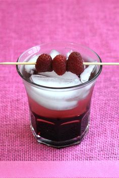 two strawberries sitting on top of ice in a glass with toothpicks sticking out of it