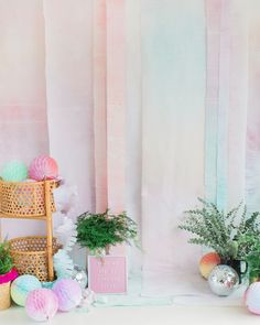 a room with pink and green decorations on the walls, potted plants in vases