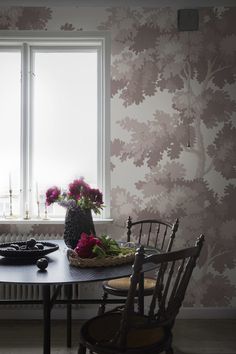 a table with some flowers on it next to a window