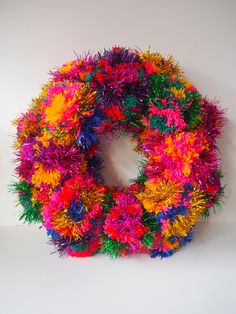 a multicolored wreath is hanging on the wall