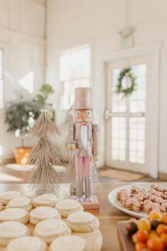 a nutcracker figurine sitting on top of a table next to cookies