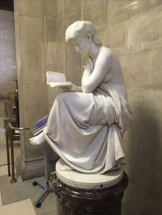 a statue of a woman reading a book