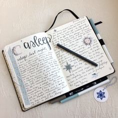 an open notebook with writing on it next to a pair of scissors and a pen