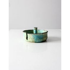 a small green bowl sitting on top of a white table