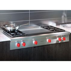 a stainless steel stove top with red knobs on the burners and side burners