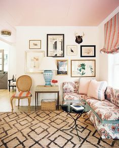 a living room filled with furniture and pictures on the wall