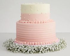 a three tiered pink and white cake with baby's breath sprinkles