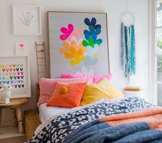 a bed with colorful pillows and blankets on it