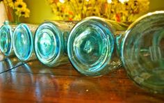 four glass vases sitting on top of a wooden table