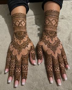 two hands with henna tattoos on them