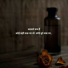 a bottle and rose sitting on a table with the words in hindi written above it