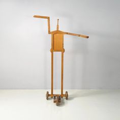 a wooden stand with wheels and a piece of wood sticking out of it's back