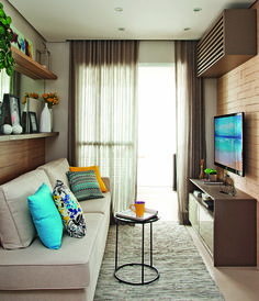 a living room filled with furniture and a flat screen tv on top of a wooden shelf