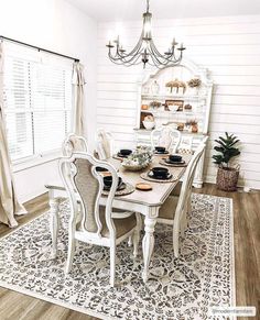 the dining room table is set with place settings for six people, and has an ornate chandelier over it