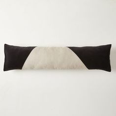 a black and white pillow sitting on top of a table