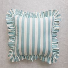 a blue and white striped pillow with ruffled edges