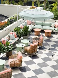 an outdoor seating area with checkered tile flooring and umbrellas on the roof