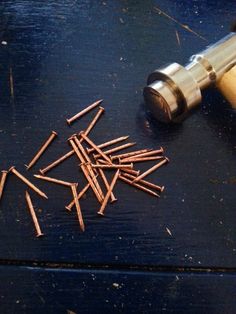 there are many nails that are on the table next to a hammer and some screws