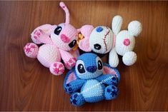 three crocheted stuffed animals sitting next to each other on a wooden floor,